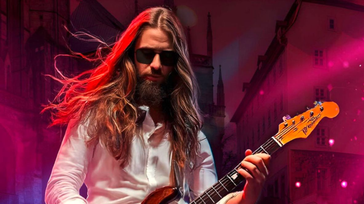 Frontalaufnahme eines Mannes, der mit einer E-Gitarre auf der Bühne steht