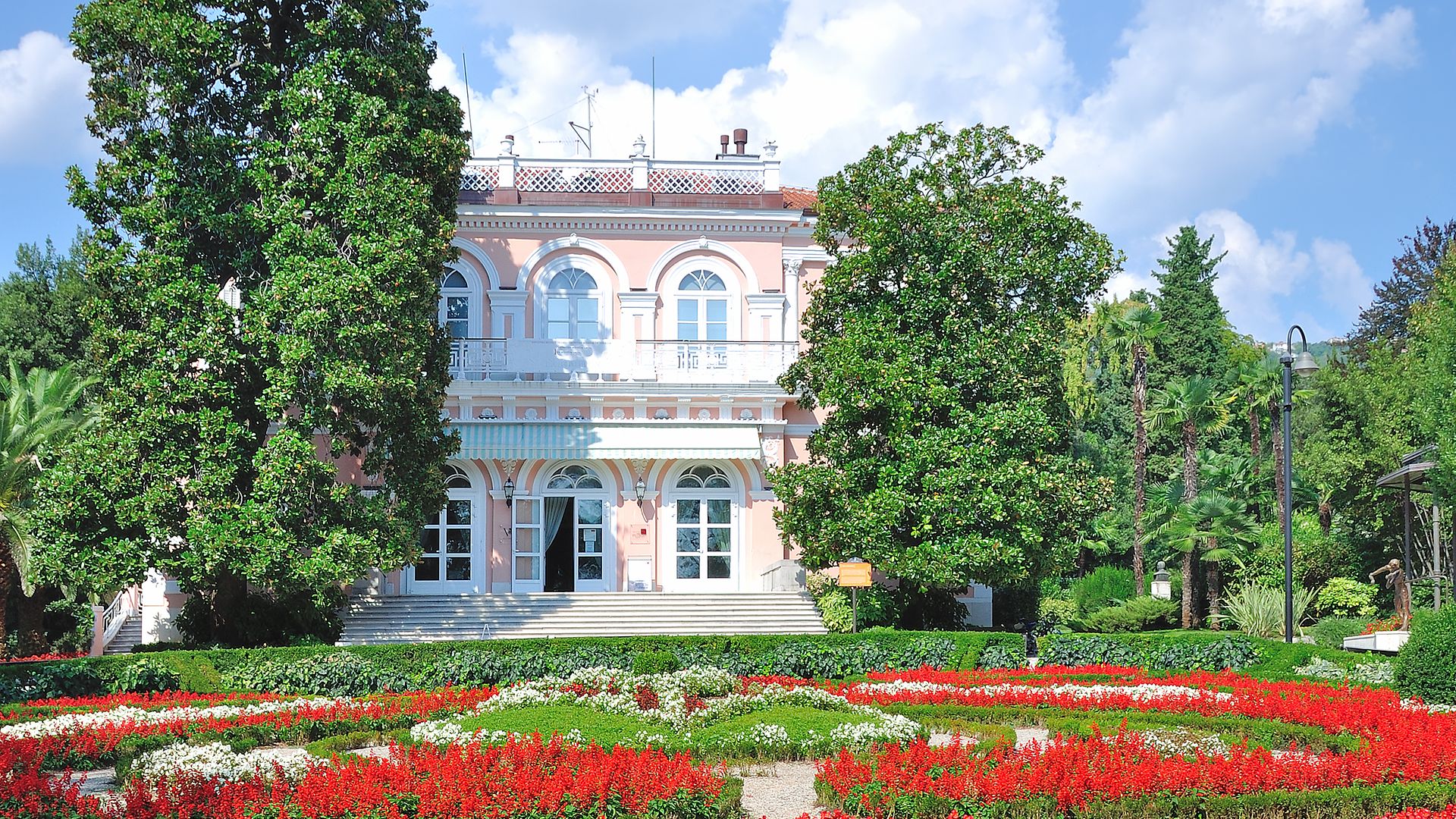 Schlossblick mit roten Blumen im Garten