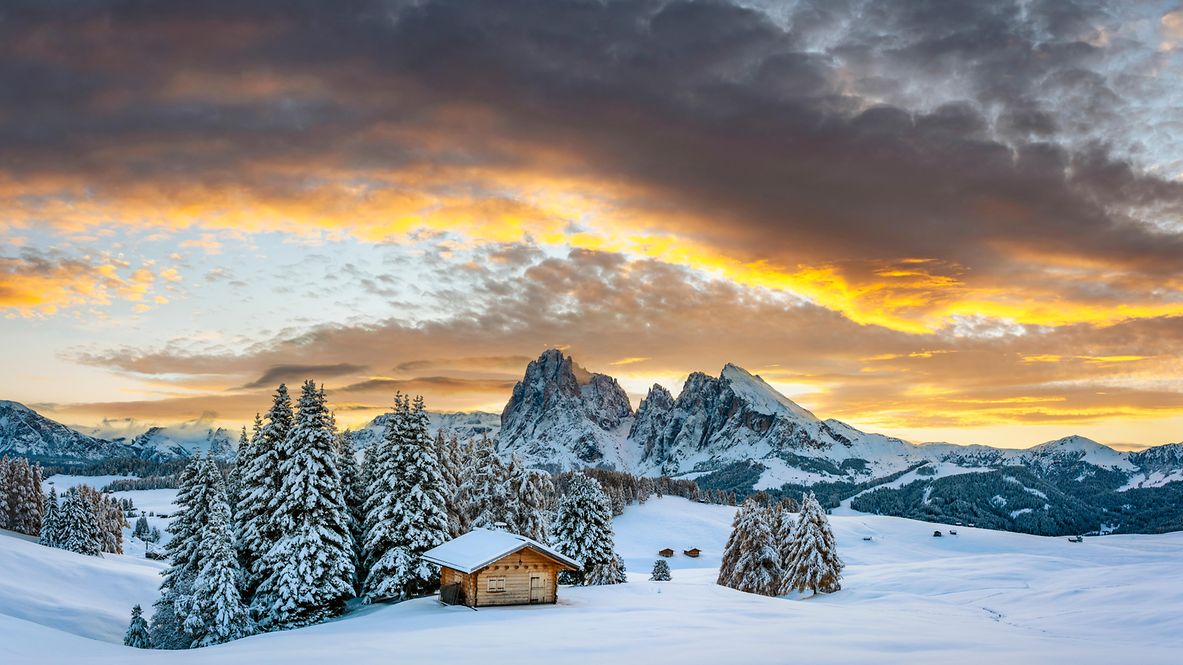 Holzblockhaus auf der Seiser Alm bei Sonnenaufgang